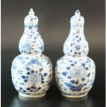 A matched pair of Chinese blue and white double gourd vases with covers, Qing Dynasty, 19th century,