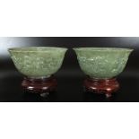 A pair of mottled spinach jadeite bowls, 20th century, each with slightly flared lip,