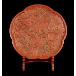 A Chinese red lacquer lobed plate and stand, 20th century, with slightly everted edges,