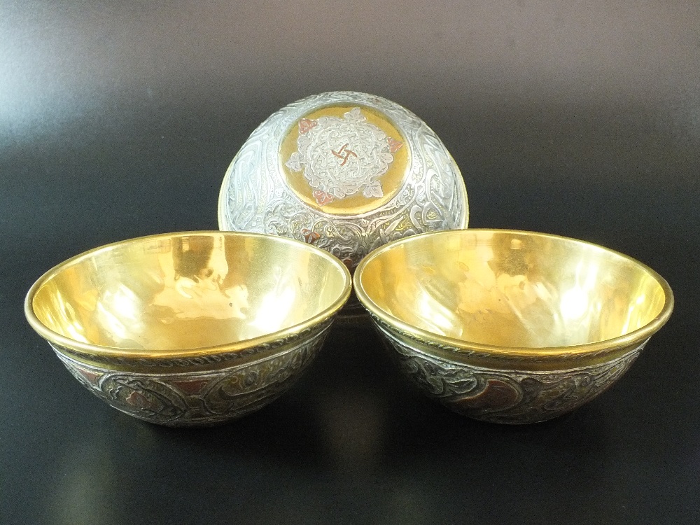 A group of three Cairoware copper and white metal inlaid brass bowls, 20th century,
