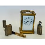 A brass carraige clock together with two metal lighters and a fountain pen