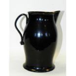 A mid-18th century Jackfield black glazed jug,