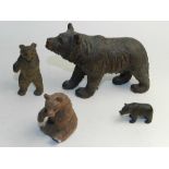 A carved wood Black Forest model of bear together with three further smaller examples