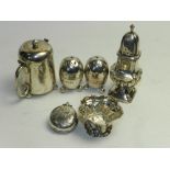 A set of three silver condiments, comprising two pepperettes and a mustard hallmarked London,