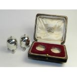 A cased pair of silver pepperettes, hallmarked Goldsmiths and Silversmiths,