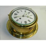 A circular brass bulkhead timepiece with enamel Roman Numeral dial