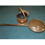 A copper warming pan and a copper coal scuttle.