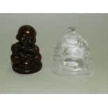 A carved wood netsuke of a seated boy together with a rock crystal carved Buddha