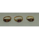 Two amethyst and seed pearl 19th century rings together with a paste set ring