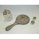 A silver backed hand mirror with scrolling decoration,