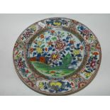 A Chinese blue and white porcelain and clobbered dinner plate decorated with flowers in a fenced