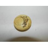 A Japanese carved ivory toggle or Netsuke of disc form incised with a scene of a boy holding a