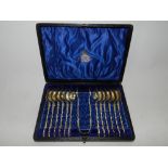 A cased set of twelve white metal apostle spoons and a pair of sugar tongs,