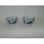 A pair of Chinese blue and white porcelain tea bowls decorated with panels of boys in garden