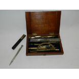A silver propelling pencil together with a cased draftsman's set and a brass mounted ebony scribe