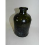 An early 19th century green glass bottle of cylindrical form with string rim