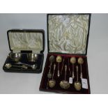 A cased set of six silver apostle spoons and tongs together with a cased silver twin salt set with