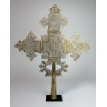 A large Ethiopian Coptic Christian white metal processional cross, mounted,