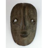 A Congolese wooden mask in the Luba style with coffee bean eyes,