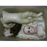 A late Victorian Continental porcelain headed doll, with brown glass eyes and painted features,