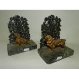 A pair of spelter book ends modelled as a seated and a standing spaniel finished in gilt and set on