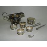 A silver sauce boat hallmarked London, together with four silver napkin rings,