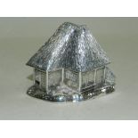 A white metal inkwell and pounce pot modelled as a thatched cottages stamped 'sterling' to the base.