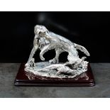 A white metal model of a hunting dog with pheasants,