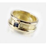 A single stone sapphire dress ring, the broad yellow metal shank stamped '375', ring size J,