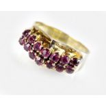 A ruby set dress ring, designed as two arched rows of seven round mixed cut rubies,