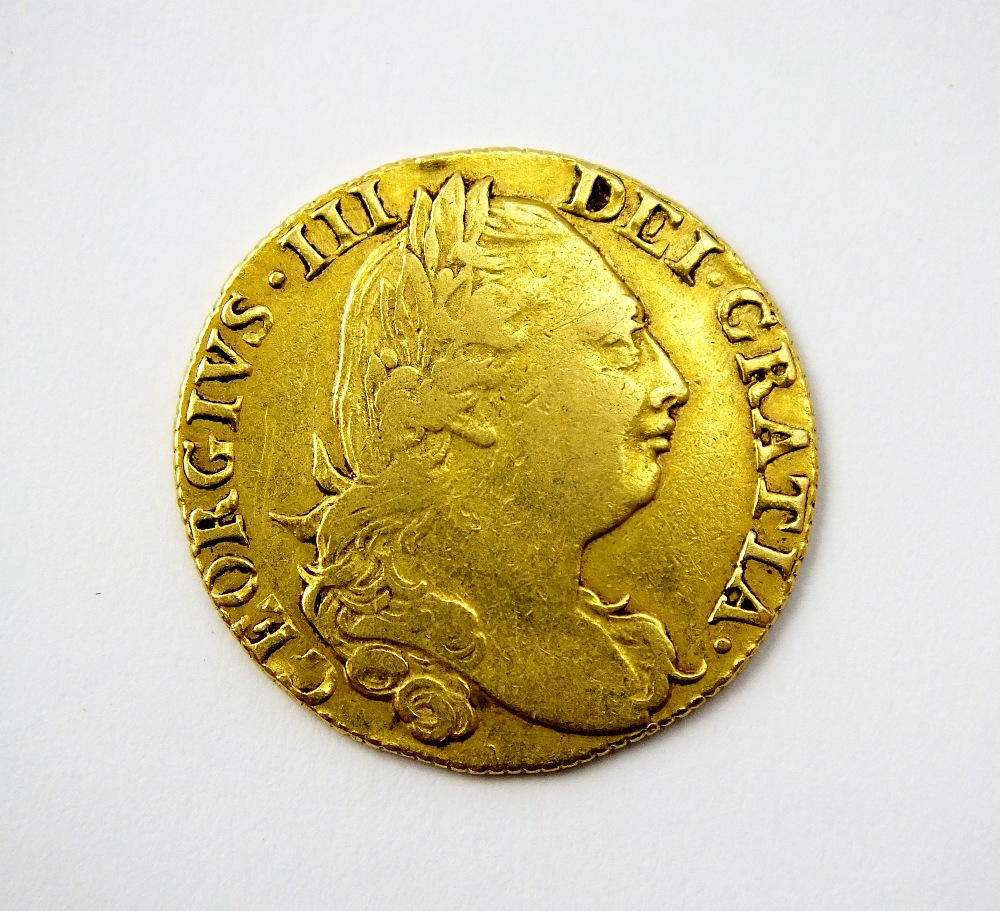 A George III guinea, dated 1775, fourth Laureate head, reverse; crowned shield of arms,