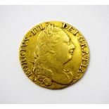 A George III guinea, dated 1775, fourth Laureate head, reverse; crowned shield of arms,