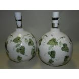 A pair of Rye pottery globe shaped lamp bases painted with trailing green foliage,