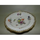 A 19th / early 20th century Meissen bowl painted with flowers and with ozier moulded rim and gilt