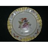 A Berlin KPM porcelain wall plate decorated with a floral spray within raised floral and gilt