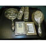 A silver four piece dressing table set together with two silver photograph frames