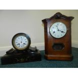 A black slate mantel clock with enamel dial and Roman numerals together with an oak cased 1920/30s