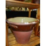 A very large terracotta and slip ware milk churn with cream slip and glazed interior