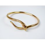 A yellow metal hollow snake bangle, stamped '9ct',
