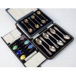 A cased set of six silver gilt coffee spoons, each with enamelled floral terminal,