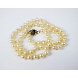 A uniform cultured pearl necklace, with sapphire and diamond clasp,