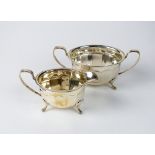 A silver sugar bowl and cream jug, Emile Viner, Sheffield 1938, each piece of faced oval form,