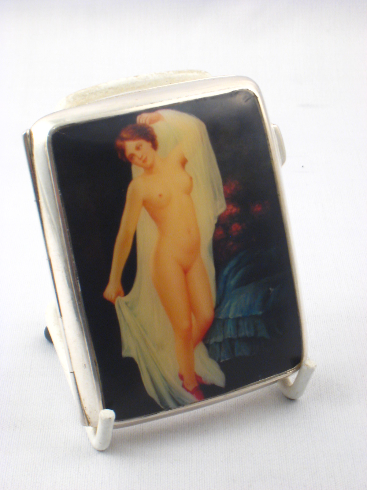 A silver curved cigarette case, the lid