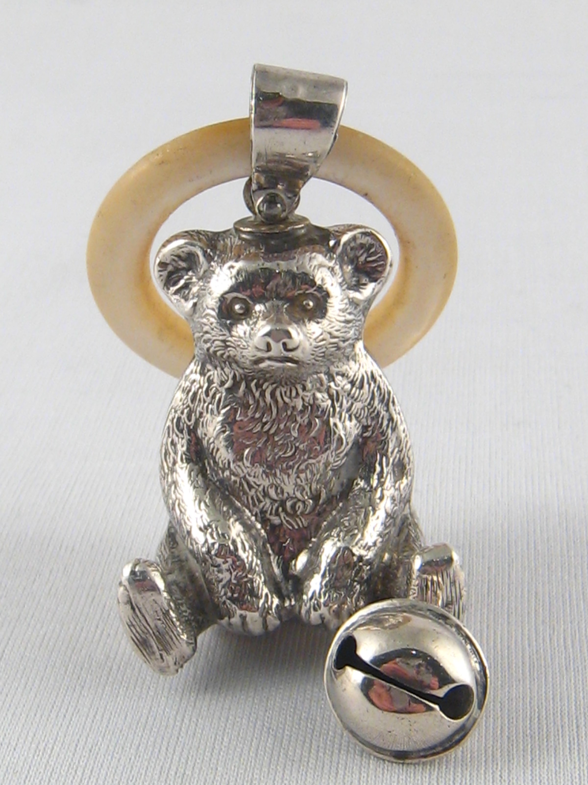 A silver teddy bear rattle with bell and