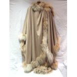 A beige cape the edges and neck trimmed