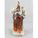 A Russian ceramic figure of a man in tra