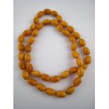 An amber necklace, approx 68cm long, bea