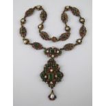 An antique silver gilt pendant necklace set with fresh water pearls, foil backed garnets,