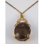 A yellow metal (tests 9 carat gold) smoky quartz pendant, the stone measuring approx 3 x 2.