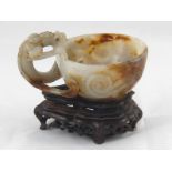 A Chinese jade bowl , the bifurcated handle carved as a dragon , the bowl representing the pearl,